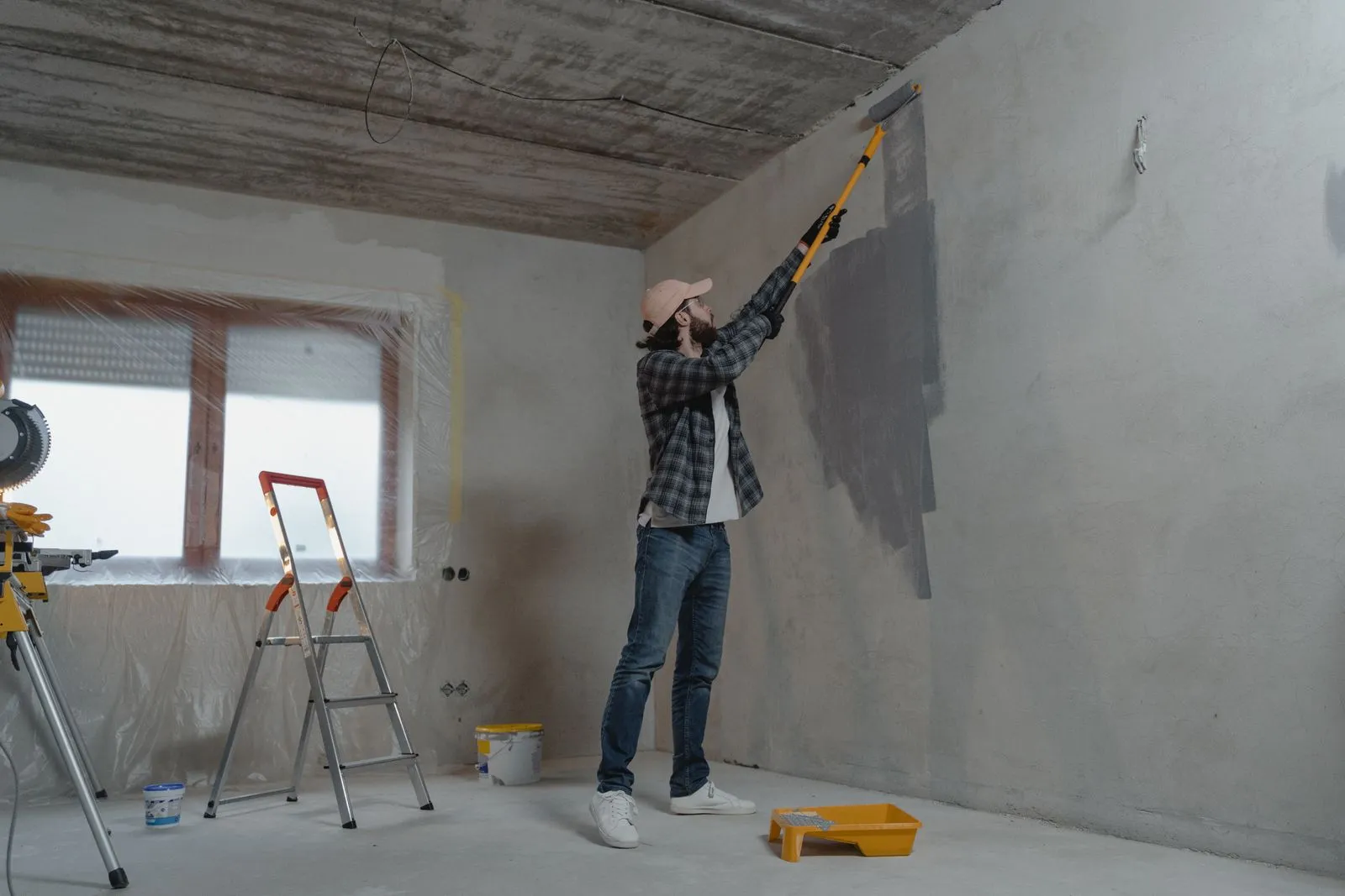 Maler beim Anstrich einer Innenwand mit der Farbrolle